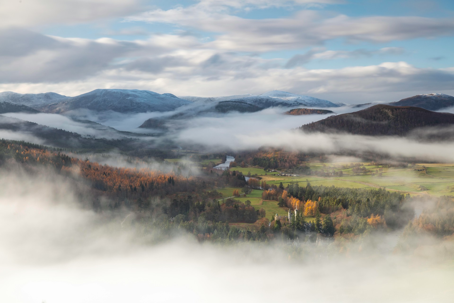 Mist drifting through a Scottish valley beneath snow-dusted hills