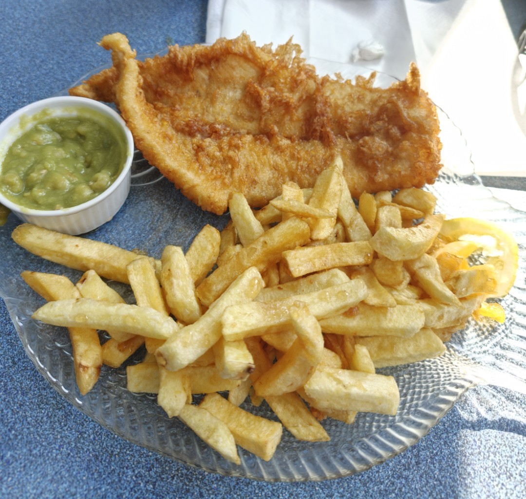 Fish and chips with a glass of whisky beside the Scottish coast