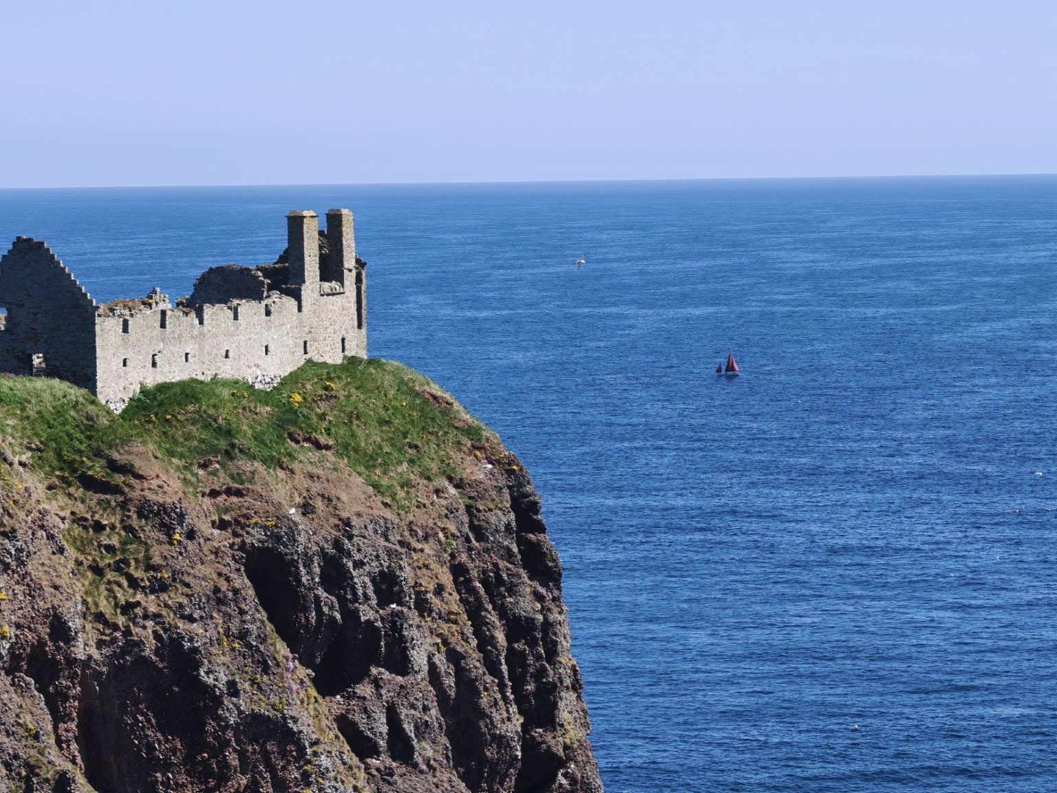 A castle on the Aberdeenshire coast beside blue water
