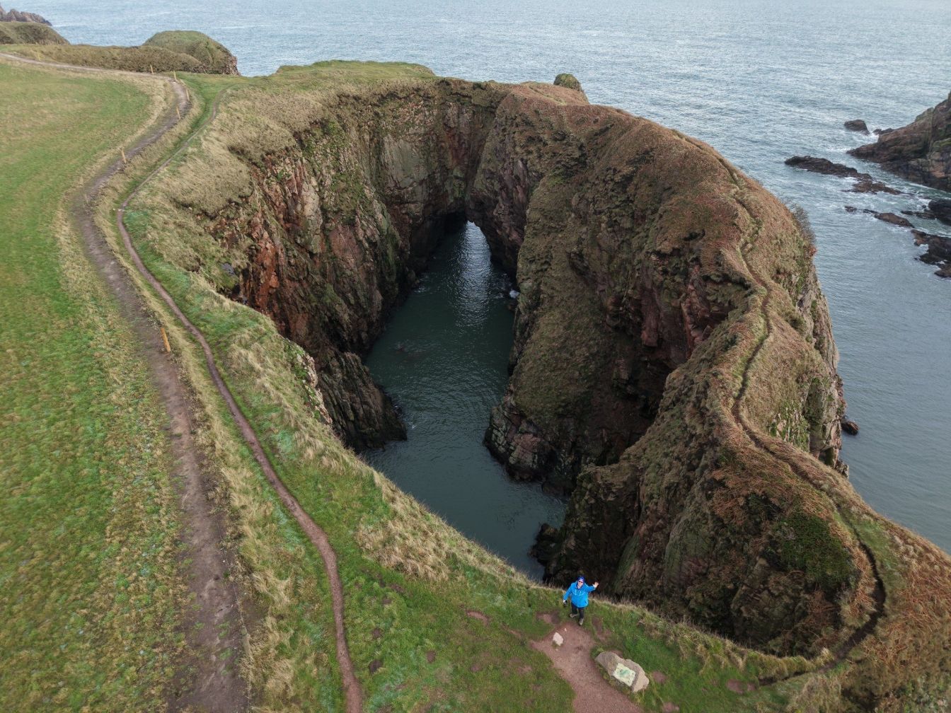 Aerial view of rocky coastal cliffs and clear water