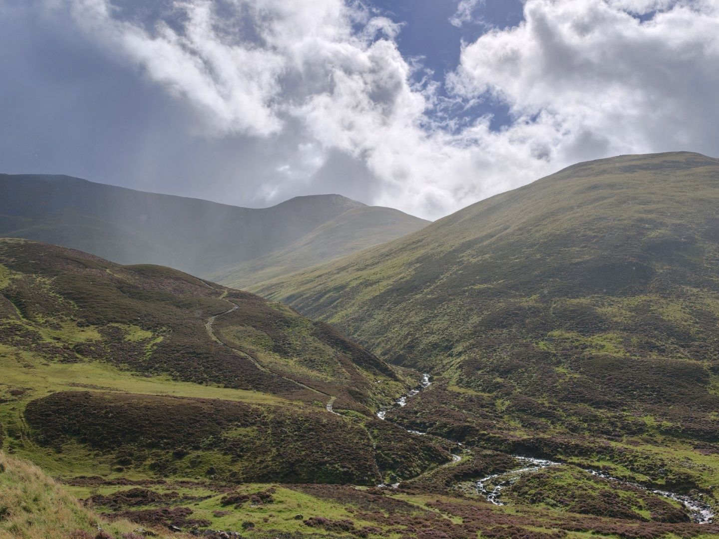 Rolling Aberdeenshire hills beneath dramatic cloud