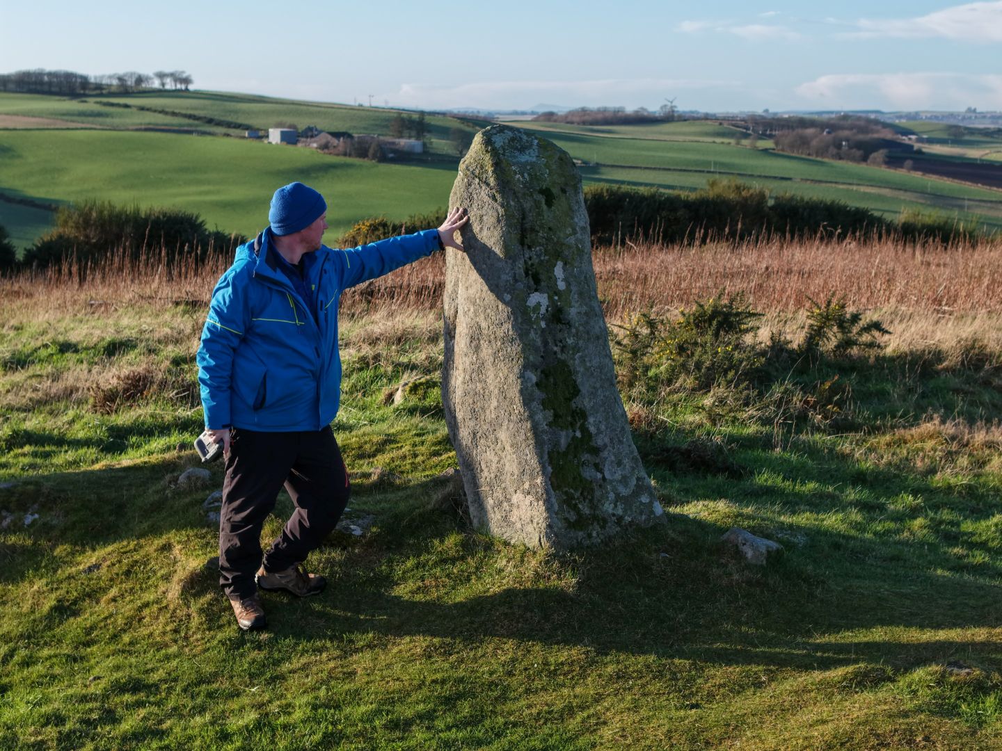 Guide next to a tall standing stone